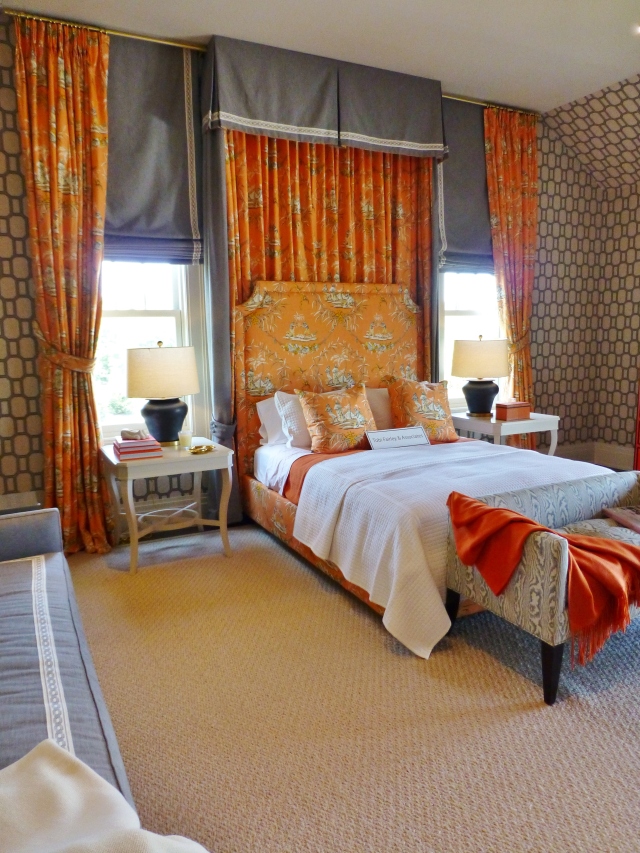 Here's a closer look at the bed wall, with it's full length draperies in the orange toile (hung all the way to the ceiling).  Tobi used grey roman shades underneath the draperies and used a beautiful tape to band the edges of both the shades and the bed hangings. The painted white side tables with their curvy legs are just perfect with the shape of those chunky charcoal lamps! The almost wall-to-wall area rug, provides a solid background and much needed relief from the heavily patterned wallpaper.  This is the perfect rug for the space.
